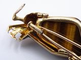 a picture of a brooch that is made out of gold