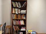 une bibliothèque dans un coin d'une pièce où se trouvent une table et des chaises