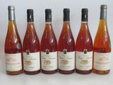 six bottles of wine are lined up in a row on a table