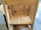 a wooden chair that has a shelf on top of it