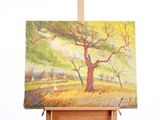 une peinture à l'huile représentant un arbre posé sur un chevalet devant un mur blanc