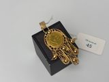 an image of a gold pendant on a black box