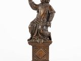 an image of a bronze statue of a man sitting on a pedestal