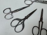 three pairs of scissors sitting on a table next to each other