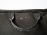 the large black bag is sitting on a white surface