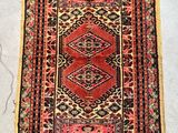 a red and black rug sitting on top of a white floor