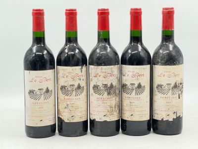 quatre bouteilles de vin sont alignées sur une surface blanche