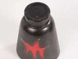 a black bell with a red star painted on it