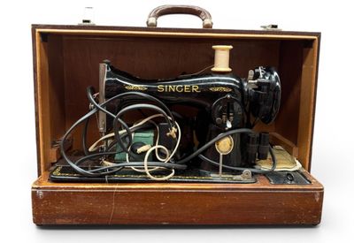 une vieille machine à coudre rangée dans un coffret en bois