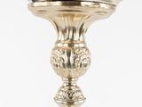 a silver candle holder with a lit candle on top of it