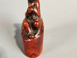 an image of a small figurine of a woman sitting on a rock
