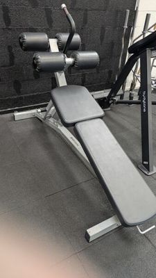a bench with a weight plate on it in a gym