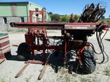 an image of a red tractor with a machine attached to it