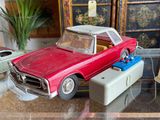 a red toy car sitting on top of a glass table