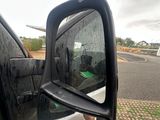 a side view mirror of a car on the side of the road