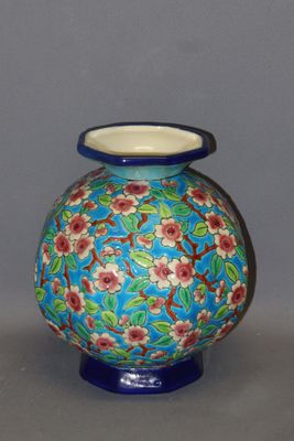 a blue vase with red flowers on it on a table