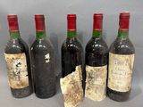 six bouteilles de vin sont alignées sur une table