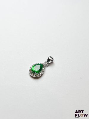 un pendentif vert en forme de larme sur fond blanc