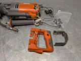 an orange and black electric tool on a metal surface