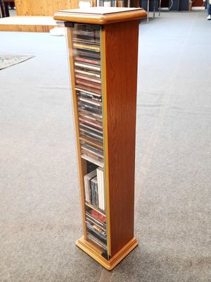 a tall wooden display case with a lot of dvds in it
