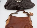two brown and black purses sitting next to each other on a table