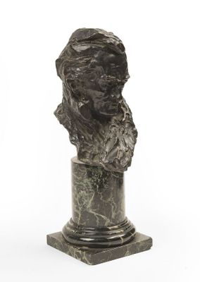 un buste antique en bronze représentant une femme, posé sur un socle en marbre