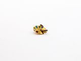 a close up of a gold plated pin with a painting palette on it