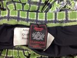 the label on a green and black dress is attached to a black and white dress