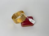 deux bagues en or munies d'une étiquette, posées sur une boîte rouge