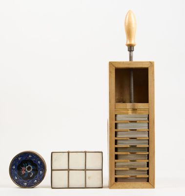 a wooden box with a clock on top of it next to a stack of books