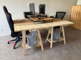 a desk with two computers and a chair in the room