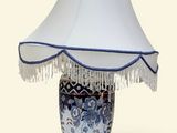 une lampe de table bleue et blanche, surmontée d'un abat-jour blanc