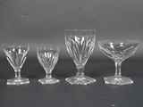 quatre verres à pied sont alignés sur une surface noire