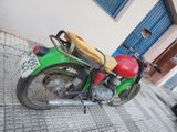 a green and red motorcycle parked on the side of the street