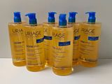 four bottles of uriage body wash sitting on a table