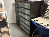 une image représentant une pièce avec un bureau, une chaise et une planche à repasser