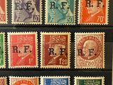 several different colored stamps on a black surface with a picture of a man and a woman