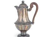 une cafetière ancienne en argent avec une poignée en bois sur fond blanc