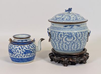 un vase bleu et blanc et une théière posés sur un socle