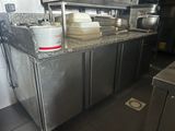 stainless steel counter top in a commercial kitchen with pots and pans on it
