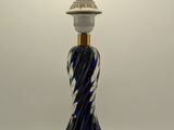 une lampe en verre bleu posée sur une table blanche