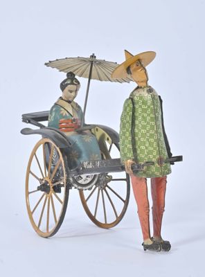 figurine of a woman in a green dress and a man in a green coat with an umbrella in a carriage