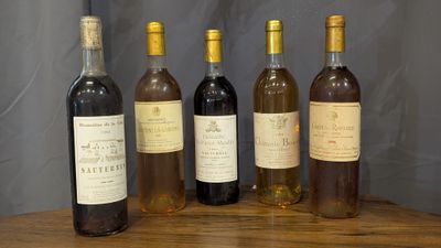 several bottles of wine are lined up on a wooden table