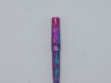 a close up of a pen on a white surface with a blue and purple background