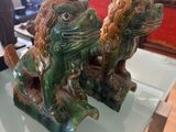 two statues of lions on a glass table in a living room