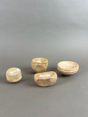 trois petits bols en bois et un petit bol posés sur une surface grise