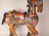 a wooden horse with a saddle on it ' s back