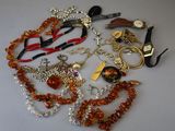 many different necklaces and bracelets laid out on a table