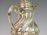 a silver coffee pot with a lid on a table