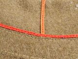 an image of a close up of a piece of clothing with orange thread